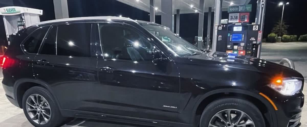 Black BMW X5 with factory chrome window trim and roof rails